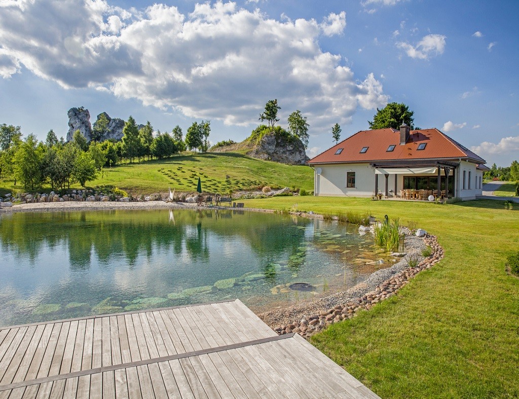 Naturschwimmteich mit Filterkammer, die unter einem Holzdeck verborgen ist