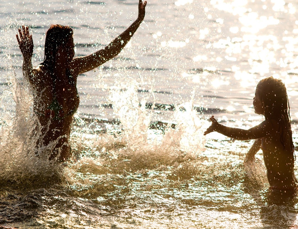 Schwimmen und spielen im klaren See. Saubere Gewässer bedeuten höhere Einnahmen aus dem Tourismus